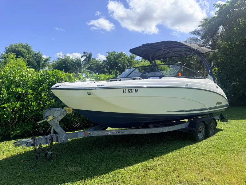 The Image of A 2020 Yamaha 242SE boat on a trailer, set on a grassy lawn. - 0