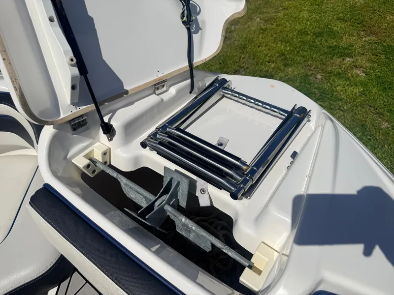 Slide: The Image of An open storage compartment on a Yamaha 242SE boat reveals a ladder and an anchor. - 15
