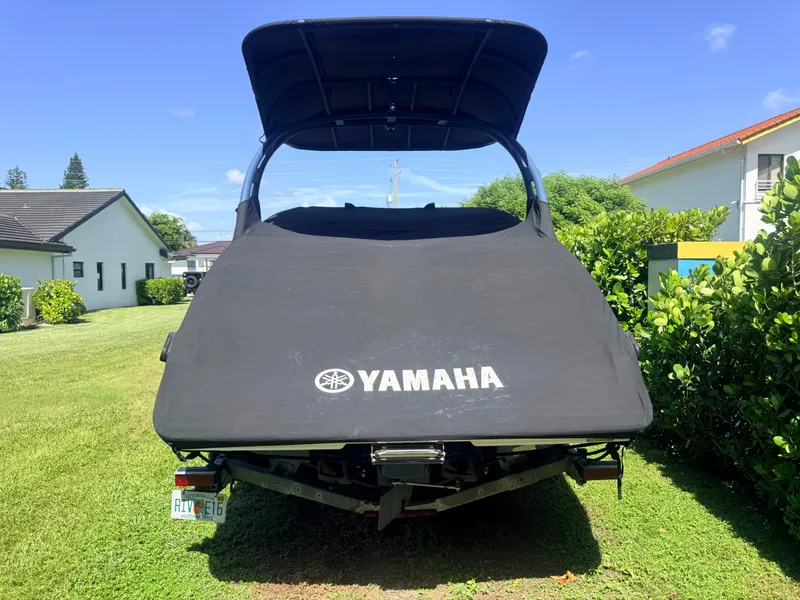 Slide: The Image of A Yamaha boat with a black cover is on a lawn, surrounded by houses and trees. - 18