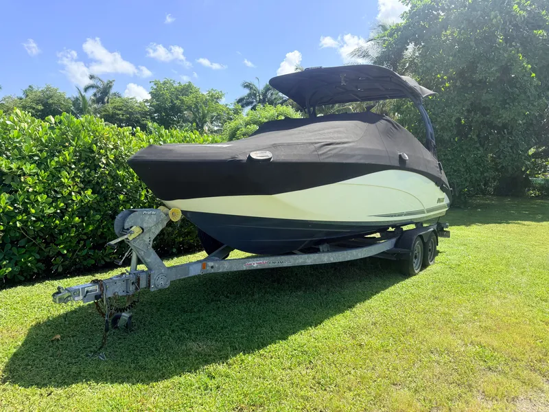 Slide: The Image of A 2020 Yamaha 242SE boat on a trailer, covered, on a grassy lawn. - 17