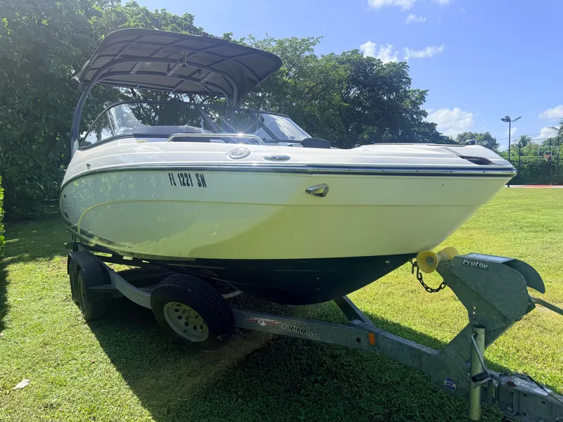 Slide: The Image of A 2020 Yamaha 242SE boat on a trailer, set on a grassy area. - 5