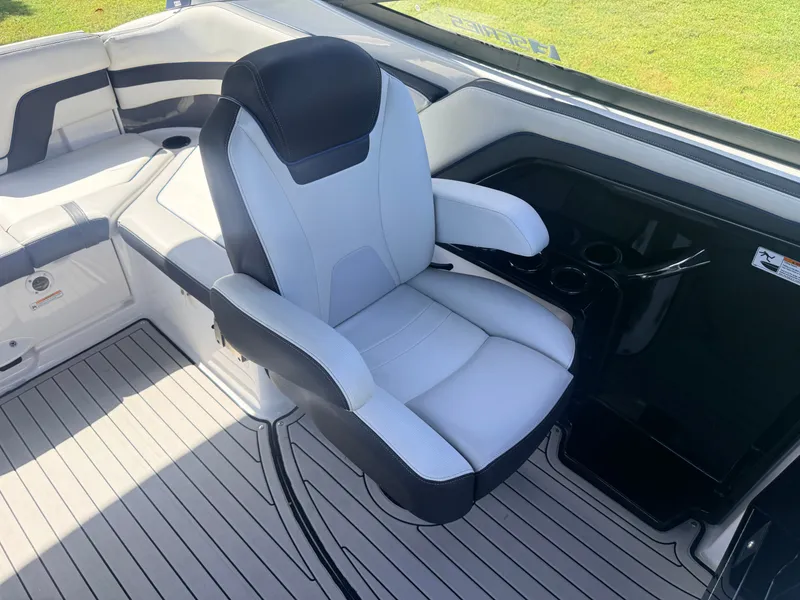 Slide: The Image of The interior of a 2020 Yamaha Boats 242SE features a cushioned captain's chair and a modern dashboard. - 10