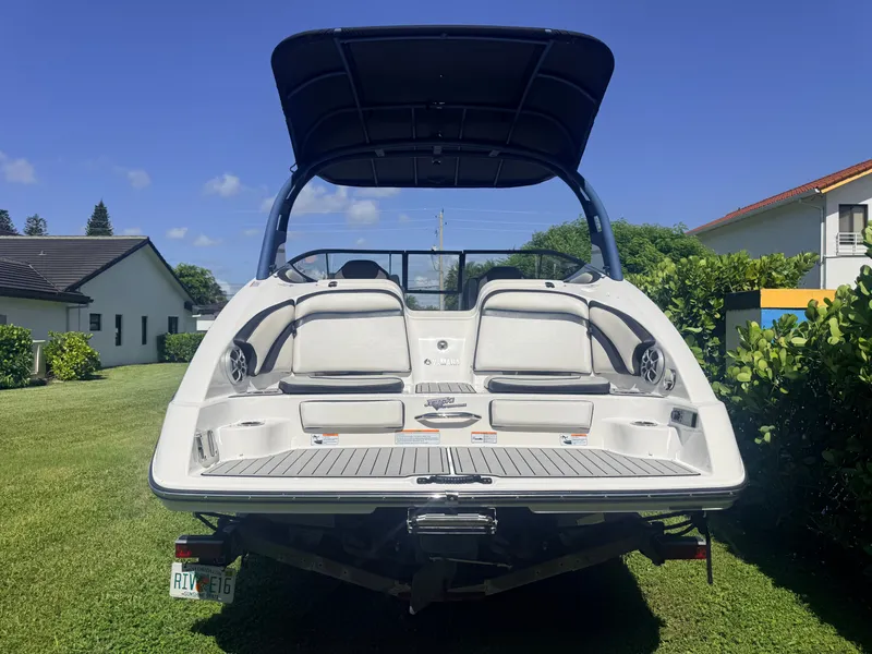 Slide: The Image of Rear view of a 2020 Yamaha 242SE boat on grass, with a blue sky in the background. - 3