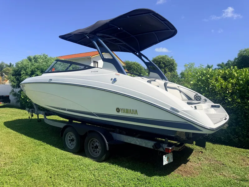 Slide: The Image of Yamaha 242SE 2020 on a trailer outdoors, featuring a black sunshade and white hull. - 2