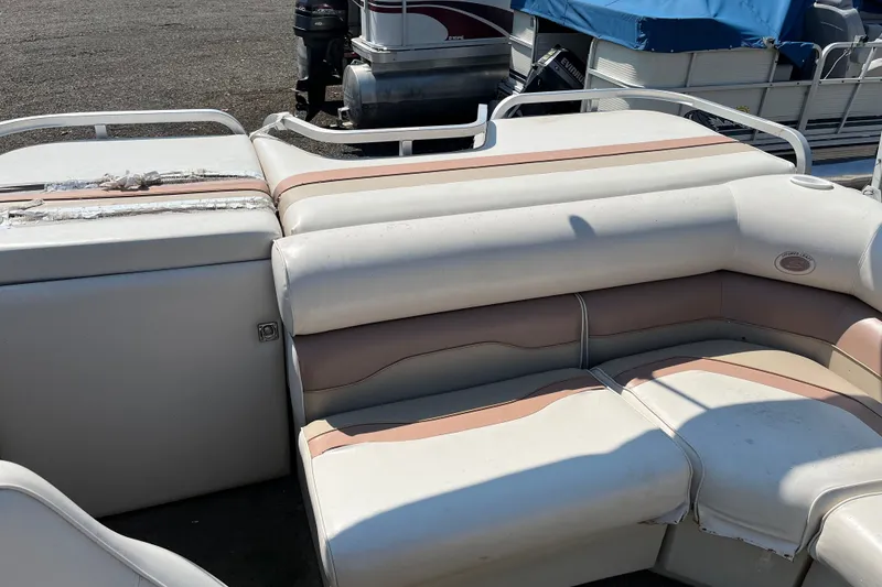 Slide: The Image of 2001 SMOKERCRAFT boat interior with white and beige seating, showing wear and tear. - 9