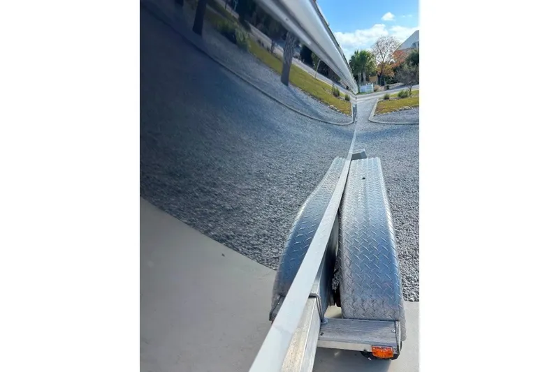 Slide: The Image of 2014 Robalo 206 Cayman boat on trailer, reflecting clear sky and trees. - 3
