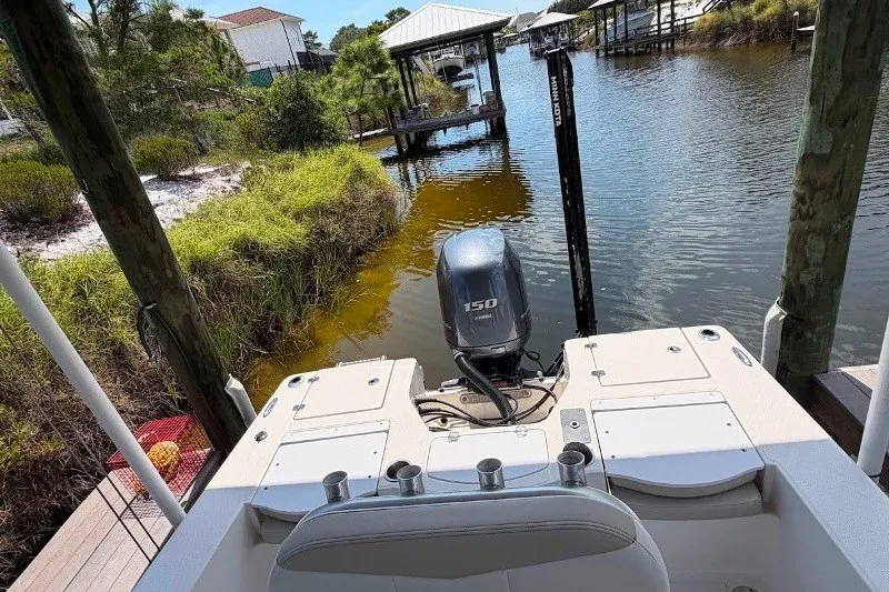 Slide: The Image of 2014 Robalo 206 Cayman boat docked by a scenic waterfront with lush greenery. - 7
