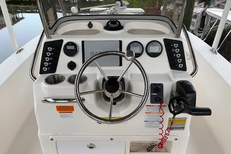 Slide: The Image of 2014 Robalo 206 Cayman boat dashboard with steering wheel and navigation controls. - 9