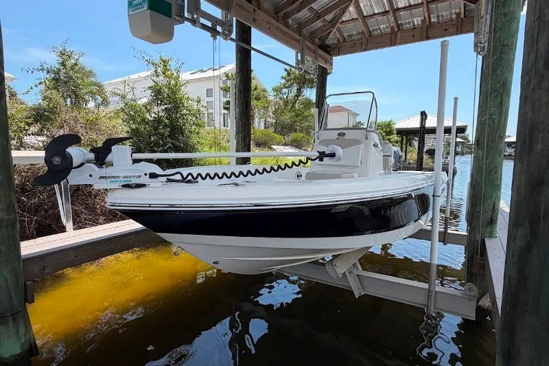 Slide: The Image of 2014 Robalo 206 Cayman boat on lift under dock shelter. - 5