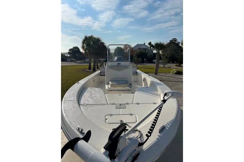Slide: The Image of 2014 Robalo 206 Cayman boat with open deck, parked outdoors under a clear sky. - 2