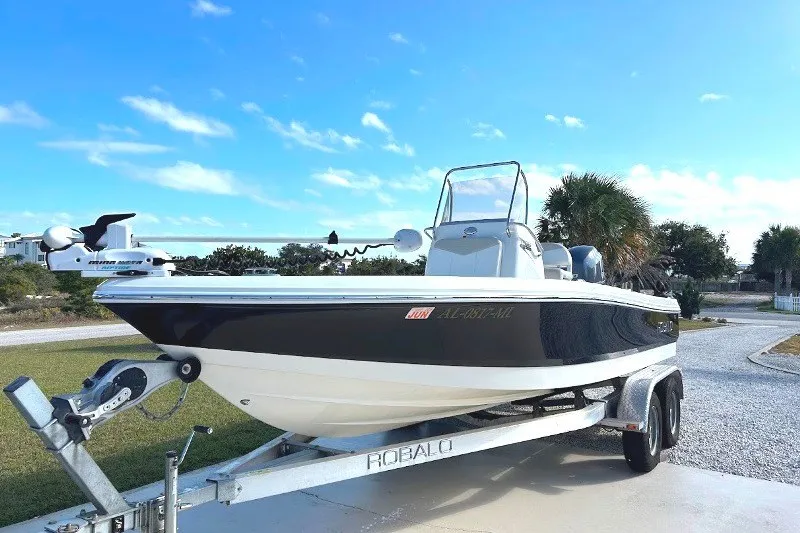Slide: The Image of 2014 Robalo 206 Cayman boat on trailer under clear blue sky. - 0