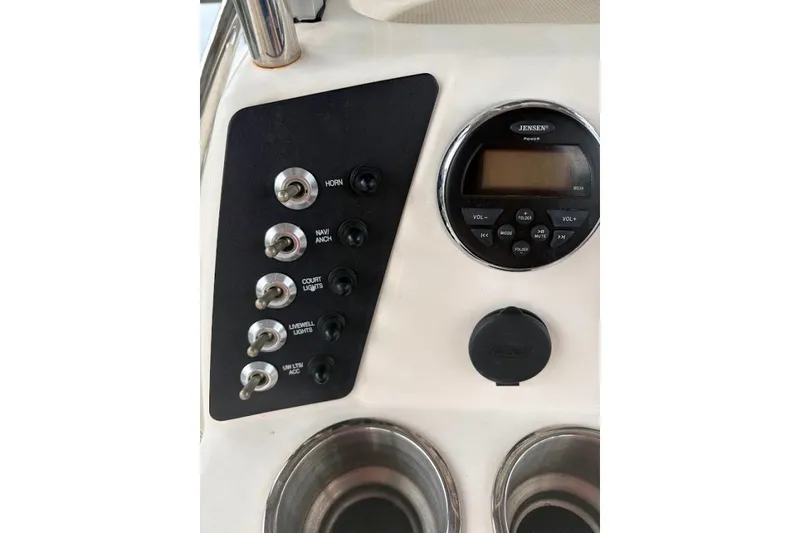 Slide: The Image of Control panel of a 2014 Robalo 206 Cayman boat with switches and a Jensen stereo. - 14