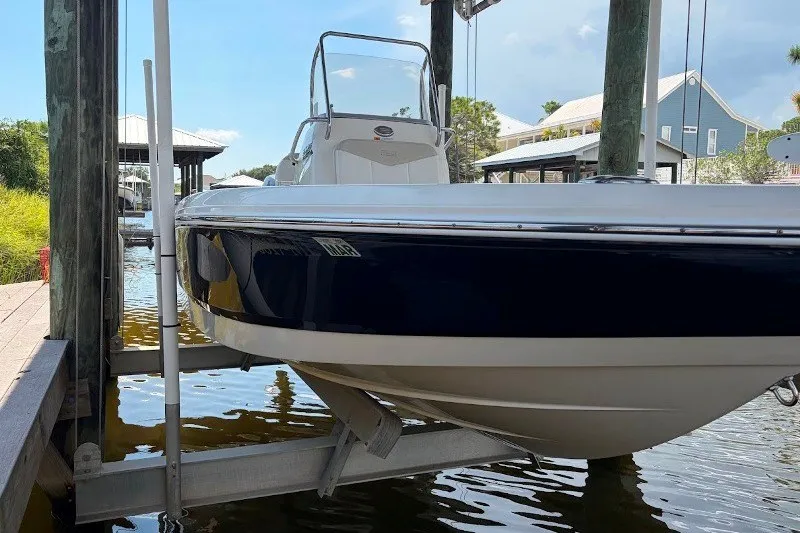 Slide: The Image of 2014 Robalo 206 Cayman boat docked on a lift in a marina setting. - 6