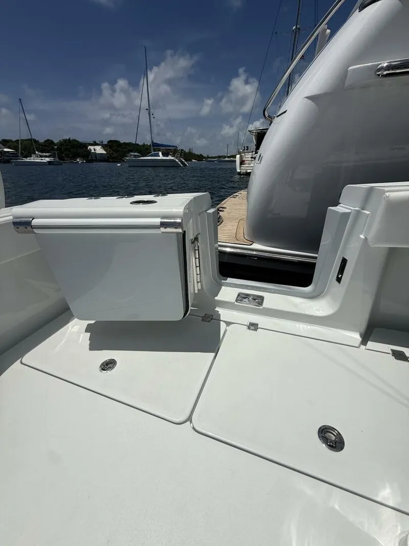 Slide: The Image of 2026 Freeman 38 boat deck with storage compartments, docked by the water under a clear sky. - 21