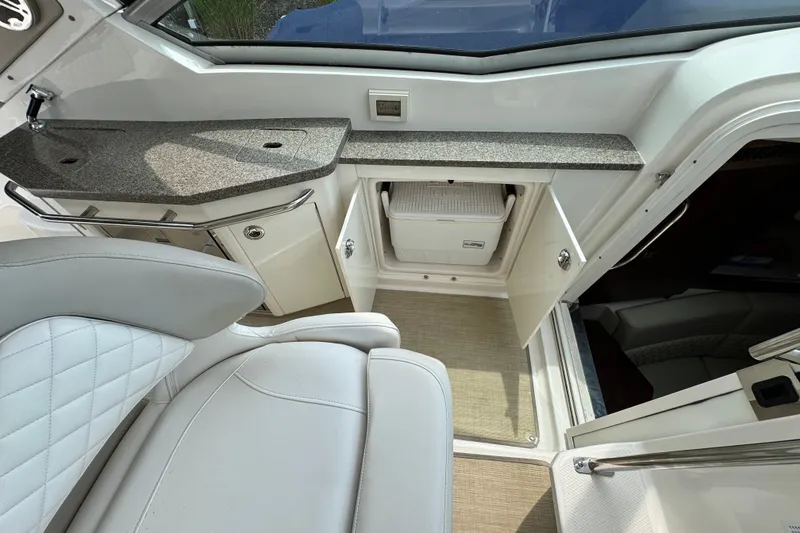 Slide: The Image of 2015 Chaparral 310 Signature boat interior with seating, countertop, and storage compartment. - 12