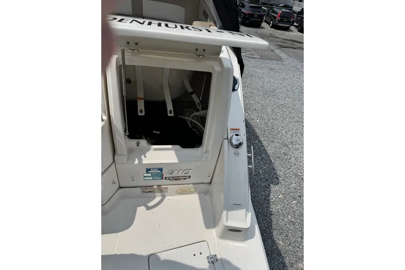 Slide: The Image of 2015 Chaparral 310 Signature boat interior with open hatch, parked on gravel. - 32