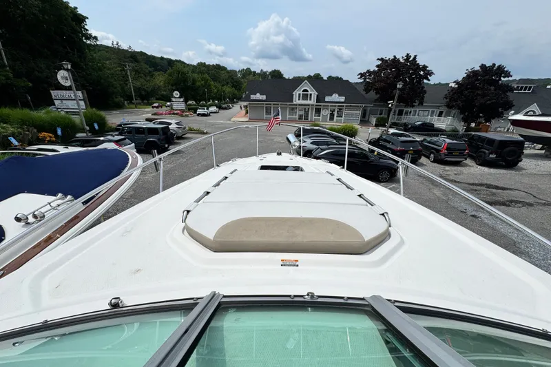 Slide: The Image of 2015 Chaparral 310 Signature boat docked, surrounded by cars and buildings. - 31
