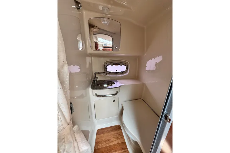 Slide: The Image of 2015 Chaparral 310 Signature boat bathroom with sink, mirror, and wooden flooring. - 23