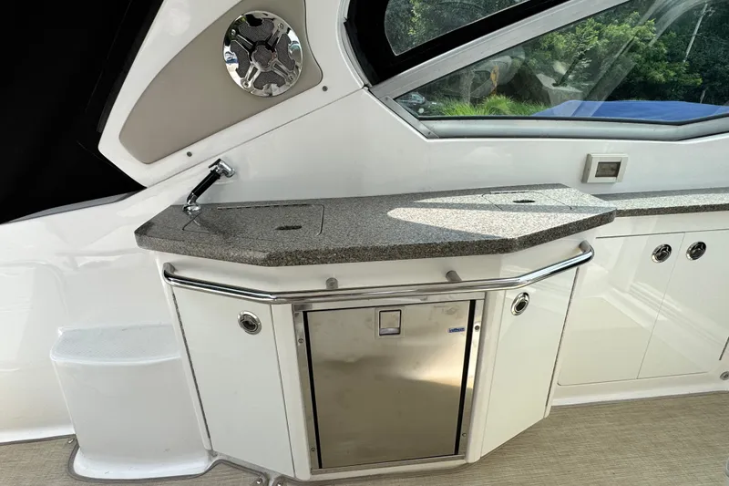 Slide: The Image of 2015 Chaparral 310 Signature boat interior with kitchenette and stainless steel fixtures. - 11