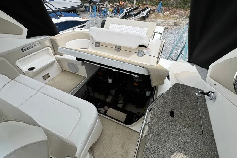 Slide: The Image of 2015 Chaparral 310 Signature boat interior with open engine compartment and seating area. - 26