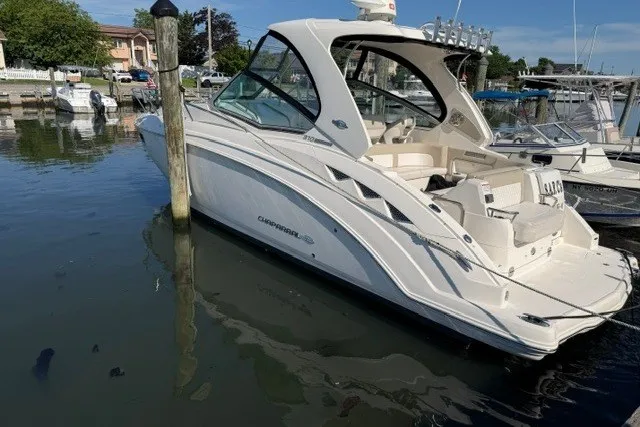 Slide: The Image of 2015 Chaparral 310 Signature boat docked in a marina, side view. - 1
