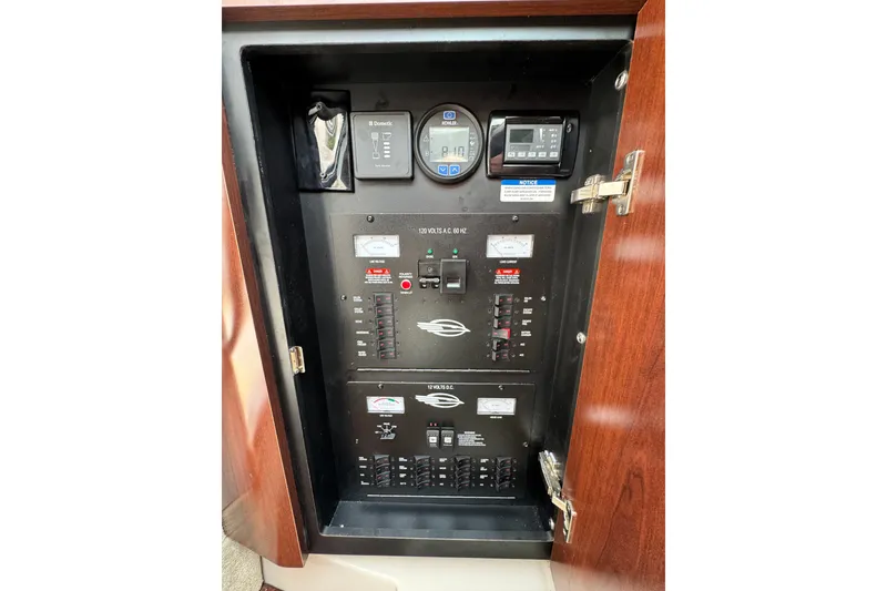 Slide: The Image of Electrical panel inside 2015 Chaparral 310 Signature boat, featuring various controls and meters. - 25