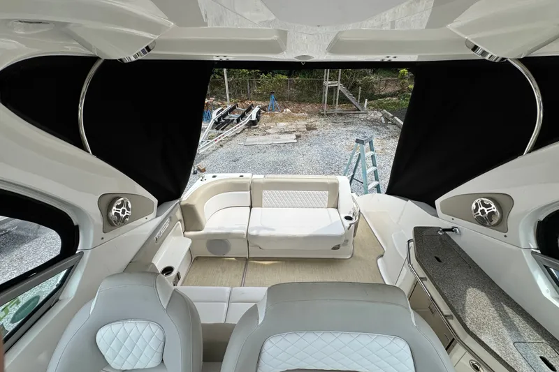 Slide: The Image of Interior of a 2015 Chaparral 310 Signature boat with seating and kitchenette. - 14