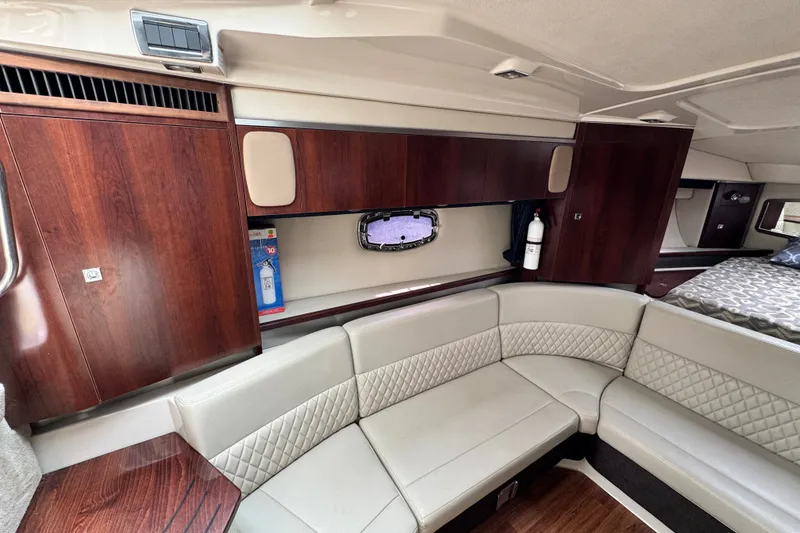 Slide: The Image of Interior of 2015 Chaparral 310 Signature yacht with elegant wood cabinetry and plush seating. - 16
