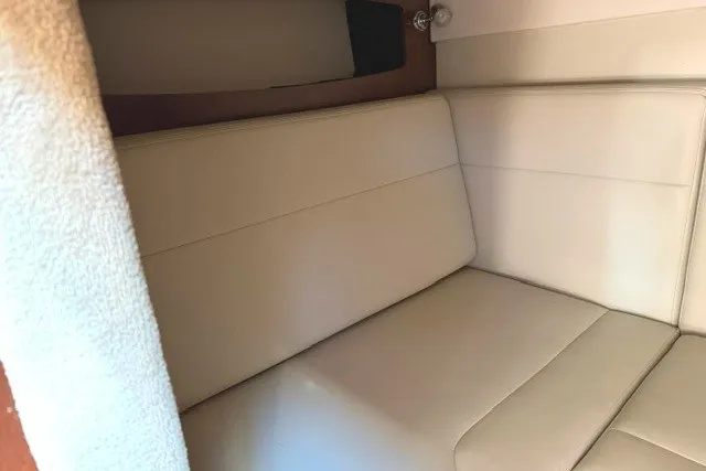 Slide: The Image of Interior seating of 2015 Chaparral 310 Signature boat, featuring beige upholstery. - 21
