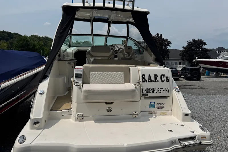 Slide: The Image of 2015 Chaparral 310 Signature boat docked in Lindenhurst, NY, with seating and helm visible. - 4