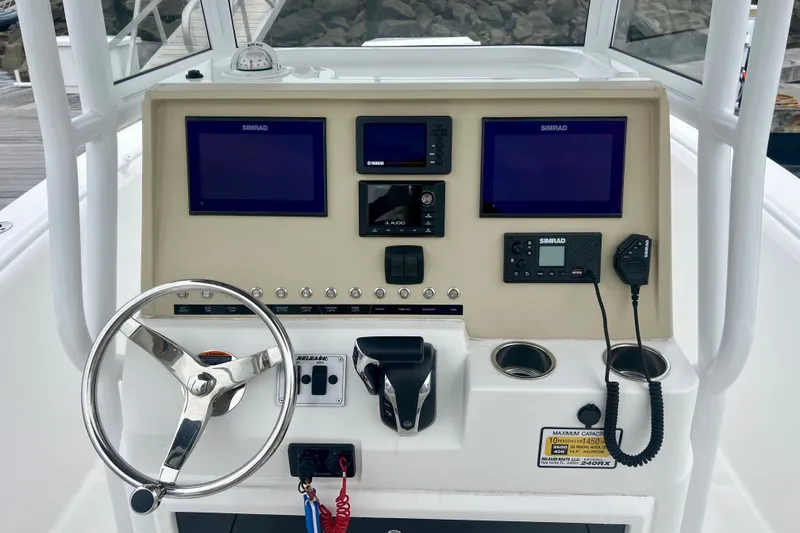Slide: The Image of Boat dashboard of 2021 Release 240 RX with steering wheel and navigation screens. - 11