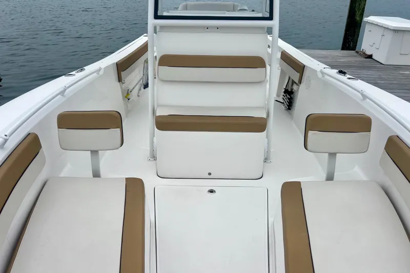 Slide: The Image of 2021 Release 240 RX boat interior with tan and white seating, dockside view. - 16