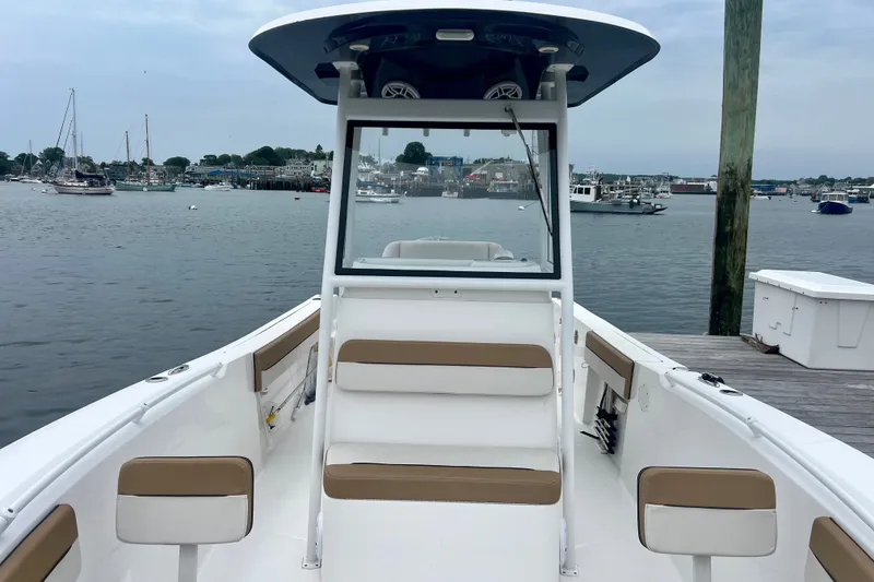 Slide: The Image of 2021 Release 240 RX boat docked at marina, featuring spacious seating and scenic harbor view. - 15