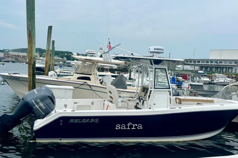 Slide: The Image of 2021 Release 240 RX boat docked in a marina, featuring a Yamaha engine. - 2