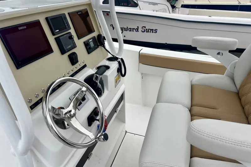 Slide: The Image of Helm of 2021 Release 240 RX boat with modern controls and beige seating. - 12