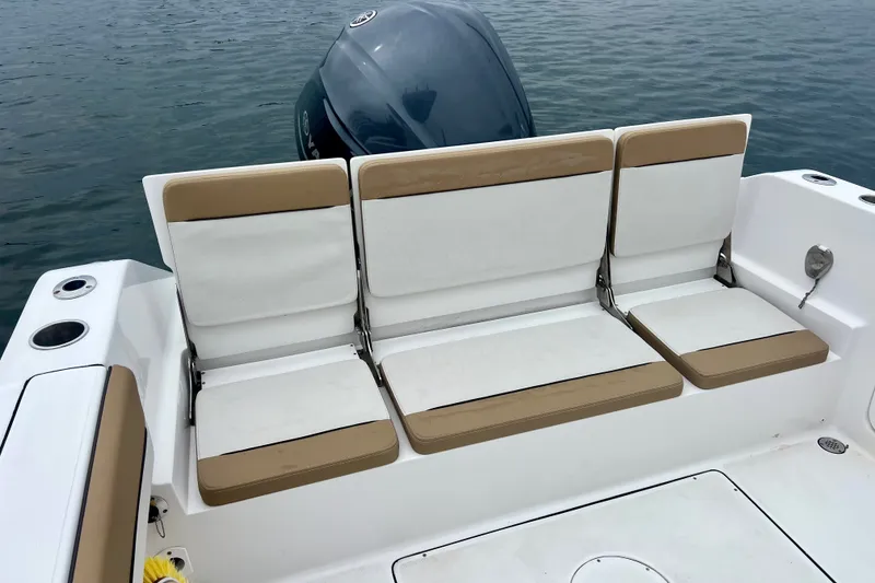 Slide: The Image of 2021 Release 240 RX boat seating with tan and white cushions, outboard motor visible. - 7