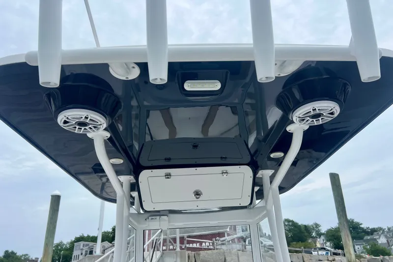 Slide: The Image of 2021 Release 240 RX boat T-top with speakers and storage compartments. - 13