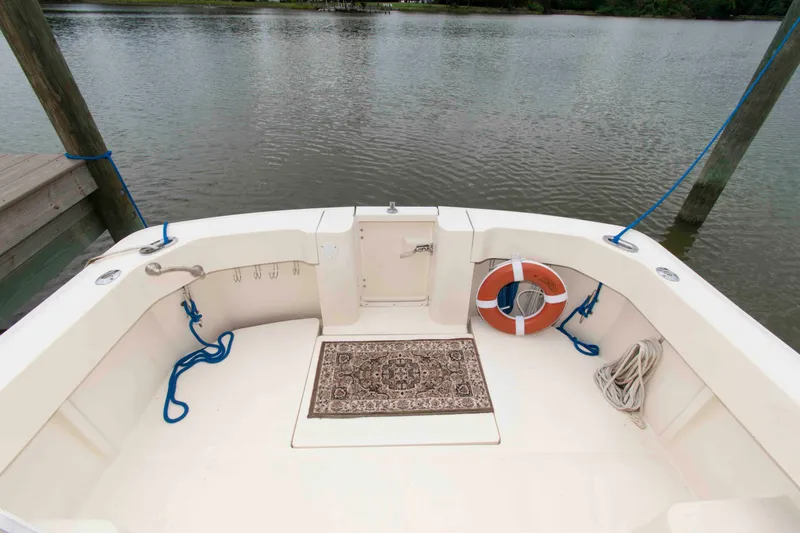 Slide: The Image of 2001 Mainship Pilot 30 boat deck with life preserver and ropes by the water. - 5
