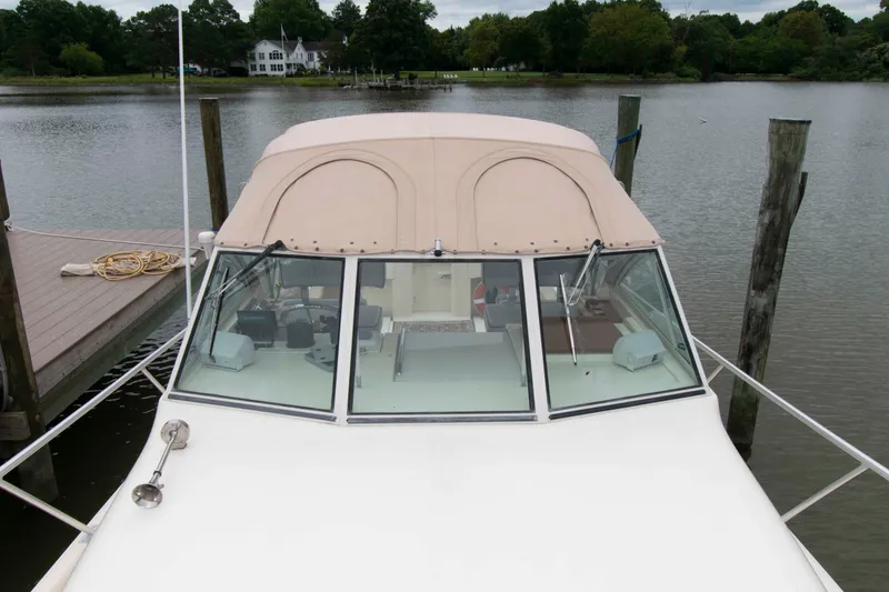 Slide: The Image of 2001 Mainship Pilot 30 boat docked on a calm lake with scenic background. - 13