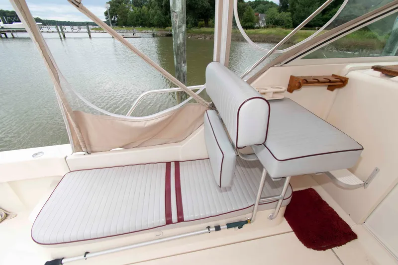 Slide: The Image of 2001 Mainship Pilot 30 boat interior with cushioned seating and water view. - 7
