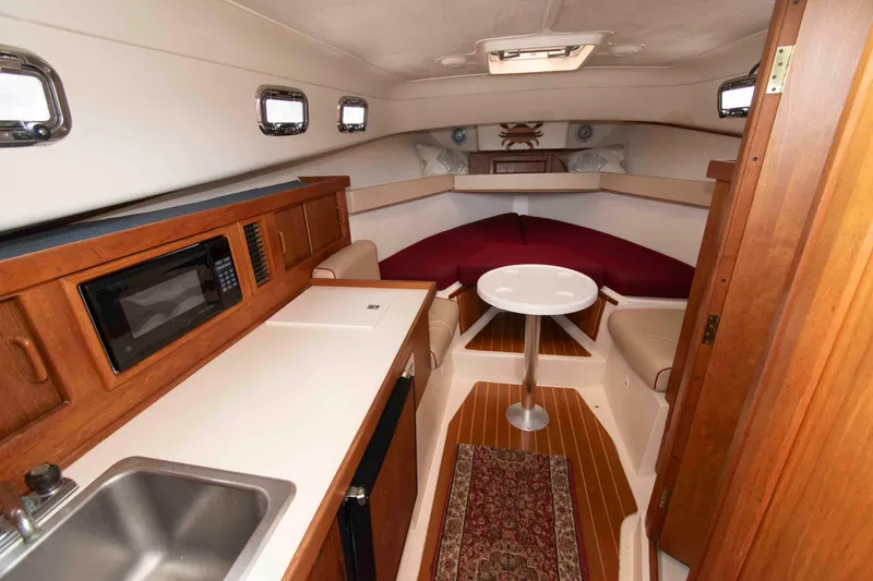 Slide: The Image of Interior of 2001 Mainship Pilot 30 boat with kitchenette and seating area. - 16