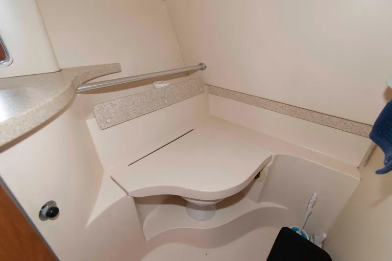 Slide: The Image of 2001 Mainship Pilot 30 boat bathroom with compact toilet and beige interior design. - 19