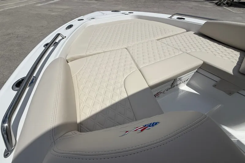 Slide: The Image of 2027 Crevalle 24 HCO boat with beige cushioned seating and stainless steel railings. - 24