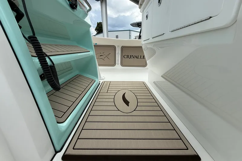 Slide: The Image of Interior view of 2027 Crevalle 24 HCO boat, featuring stylish flooring and branding. - 18