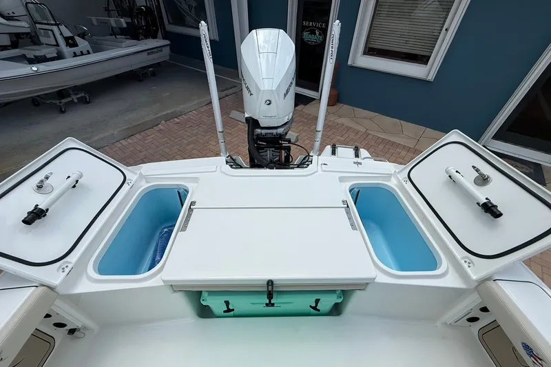 Slide: The Image of 2027 Crevalle 24 HCO boat with open storage compartments and Mercury engine. - 8