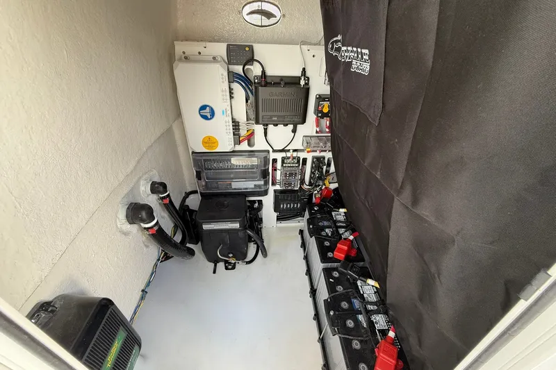 Slide: The Image of Electrical compartment of 2027 Crevalle 24 HCO boat with batteries and wiring. - 29
