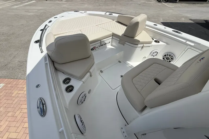 Slide: The Image of 2027 Crevalle 24 HCO boat interior with beige seating and cup holders. - 21