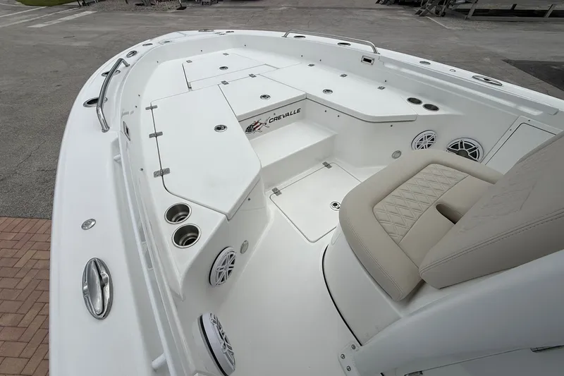 Slide: The Image of 2027 Crevalle 24 HCO boat interior with seating, cup holders, and storage compartments. - 22