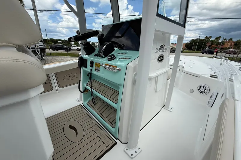 Slide: The Image of 2027 Crevalle 24 HCO boat console with modern controls and seating under a cloudy sky. - 12
