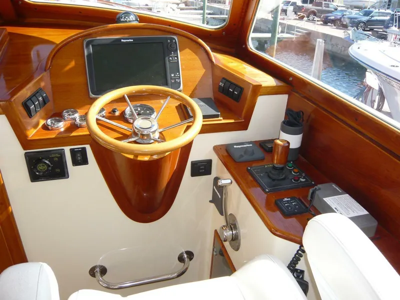 Slide: The Image of Helm of 1998 Hinckley 36 Classic boat with wooden steering wheel and navigation equipment. - 16